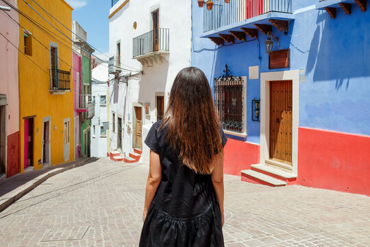 Woman Walking Through Colorful Colonial Streets