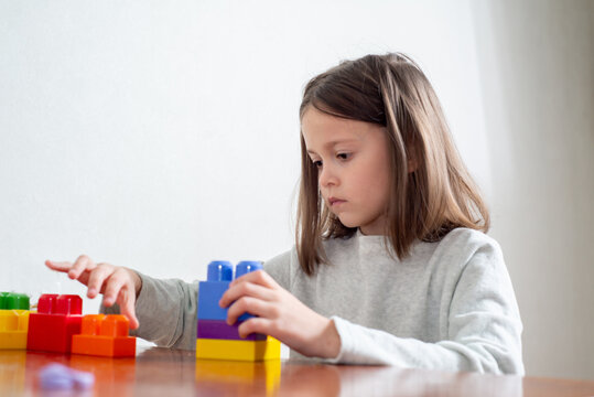 child with autism lines up colorful toy blocks