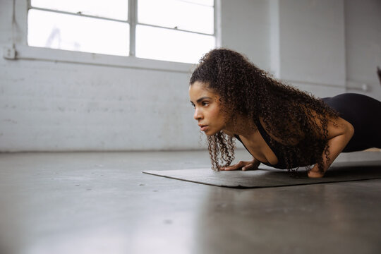 Confident Woman Practicing Strength Training in a Bright Studio