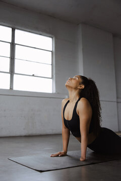 Woman Practicing Yoga in Studio Emphasizing Strength and Flexibility