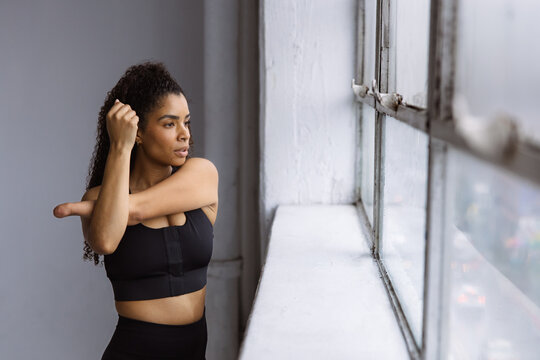 Woman Stretching Her Arm in Studio by Window