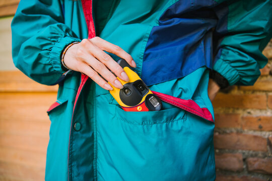 Camera in teal windbreaker