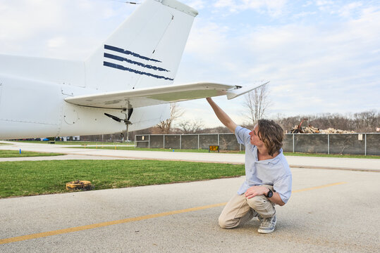 Student pilot inspecting wings