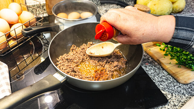 Woman pouring sweet paprika