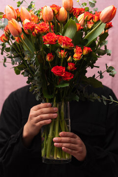 Fashion model wearing black shirts holding a red colorful flowers