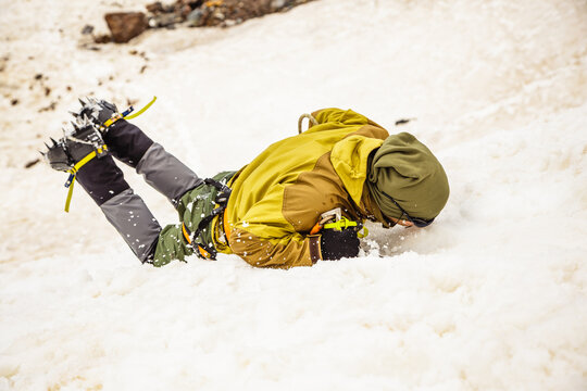 Climber tumbles on snowy slope during mountaineering adventure