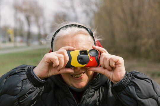 Senior woman with Disposable camera