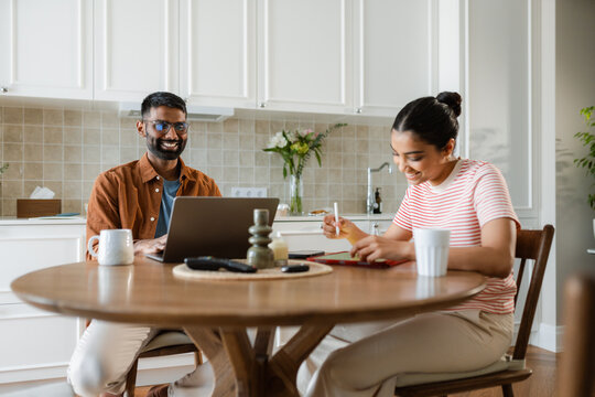 A man and a woman use gadgets at home