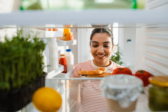 A woman takes food out of the refrigerator