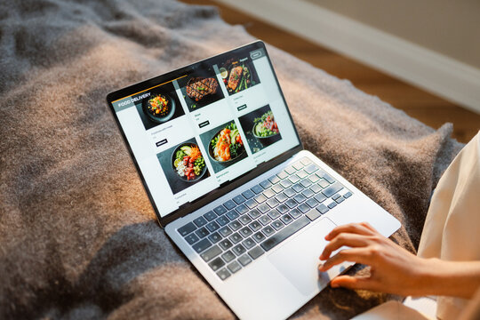 A woman makes an online food order on a laptop