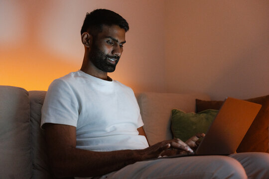 A man uses a laptop at home