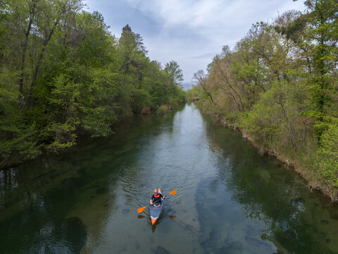 Rowing kayak in gorgeous river. Clean water, embracing trees