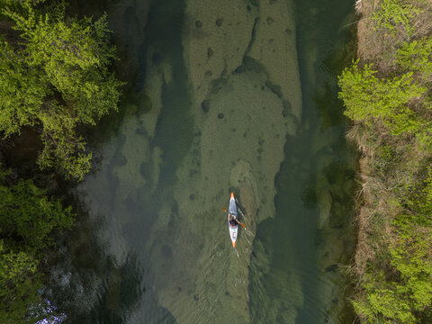Drone view kayaker in clear river 