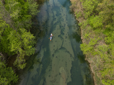 Drone image of kayaker rowing on clear water