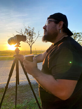 Photographer drinking coffee at sunset