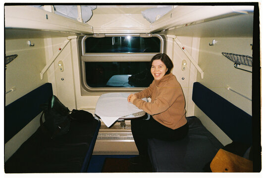 Woman enjoying a journey in a train compartment