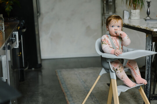 Adorable Baby Sitting in Highchair in Modern Bright Kitchen Setting