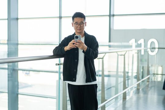 Asian Man Using Smartphone at Airport