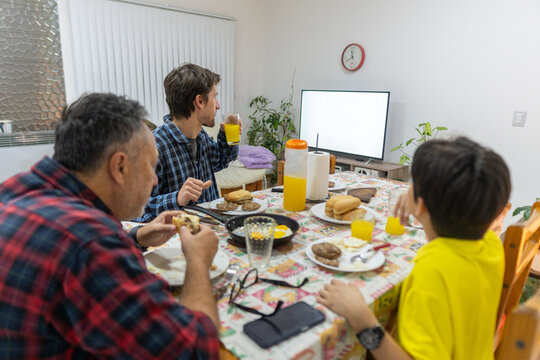 Family with TV screen and smartphone on table