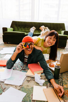 Students taking photos with instant camera while studying at home