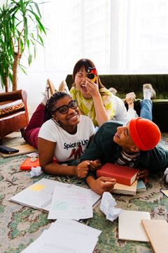 Students taking pictures and having fun while studying on the floor