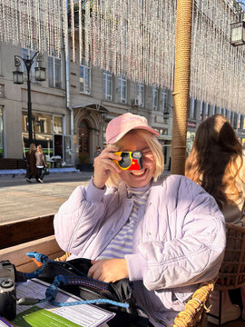 Smiling Woman Taking Photo with Disposable Camera
