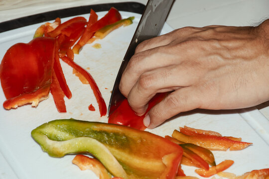 Person slicing bell peppers
