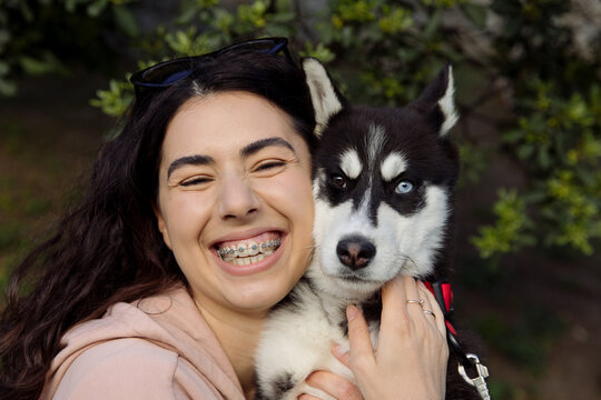 young woman hugging her husky puppy