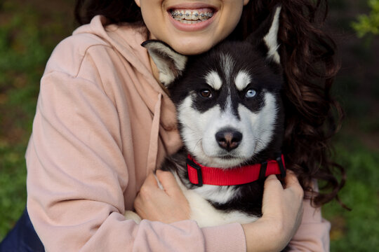 young woman hugging her husky puppy