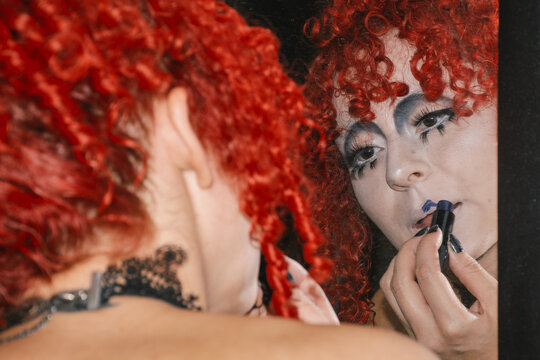 Woman wit gothic makeup applying lipstick 