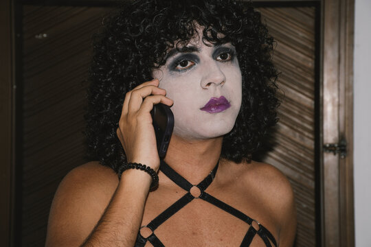 Man with gothic makeup talking on cellphone