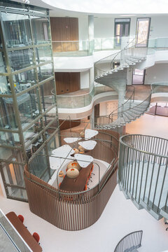 Atrium Workspace With Glass Elevator And Spiral Stairs

