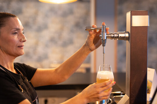 a waitress pouring a glass of beer