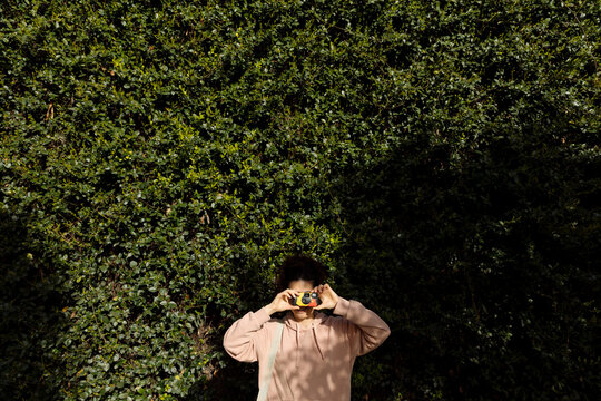 A young woman takes a picture with a disposable film camera