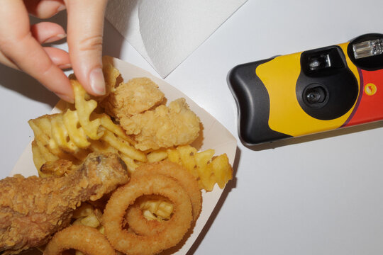 a disposable film camera lies on a table in a fast food restaurant