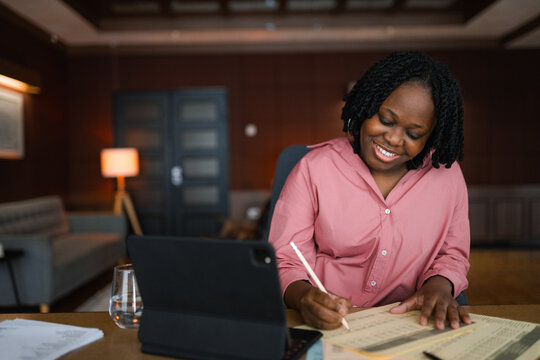 A woman studies documents sitting at her desk