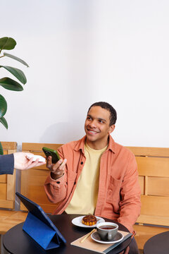 Man Smiling During Mobile Payment with smartphone 