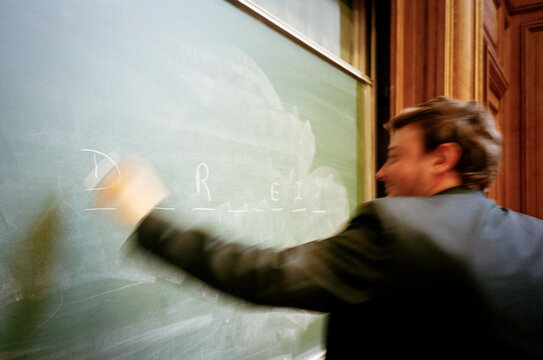 Professor writing in a blackboard 