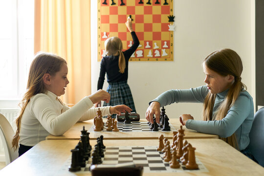 Girls Playing Chess and Learning Strategy
