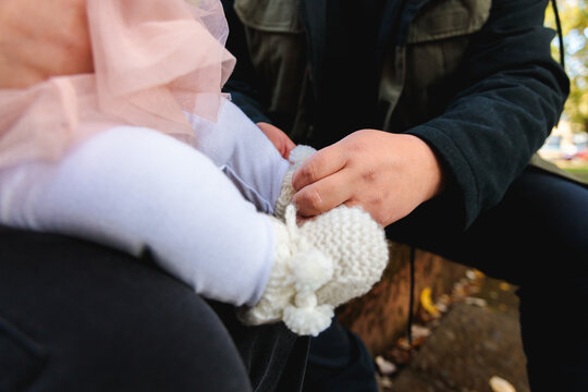 Father&rsquo;s hands tying the woolen shoes of his baby