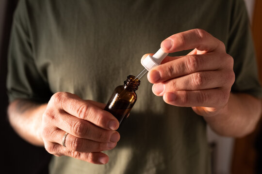 Man holding bottle with beard oil and dropper