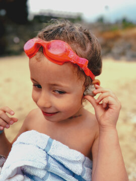 A girl listens for the sound of the sea in a shell