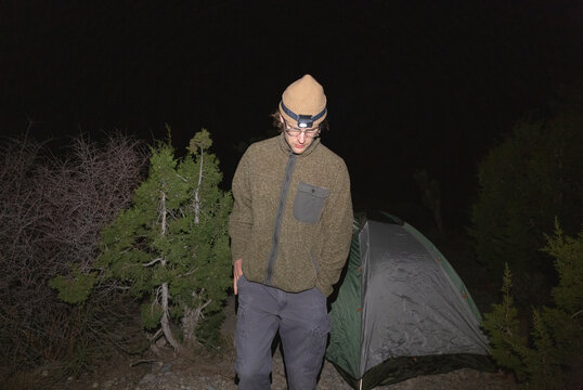 Man setting up tent late at night