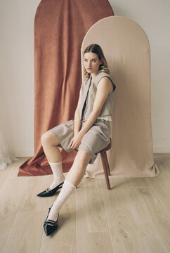 Film photography of fashion model posing on chair 