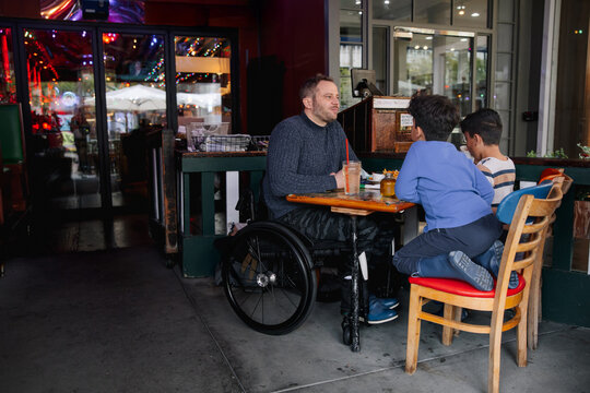 Father Enjoying Quality Time With Sons at Outdoor Restaurant