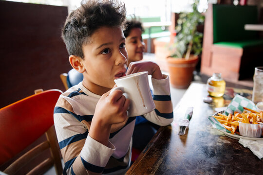 Young Boy Enjoying Hot Beverage in a Cozy Caf&Atilde;&copy; Setting
