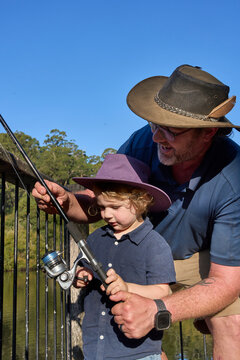 Dad and son Fishing on Wooden Platform in Countryside Setting