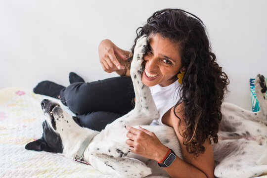 Playful moment between latina woman and her rescue dog