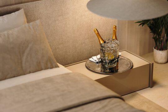Luxury hotel bedroom setup with champagne and ice bucket on nightstand