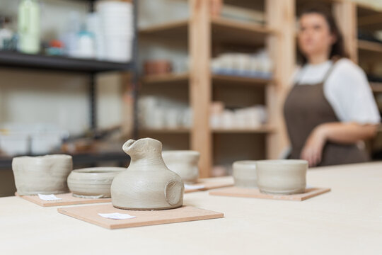 Artisan observing completed pottery pieces